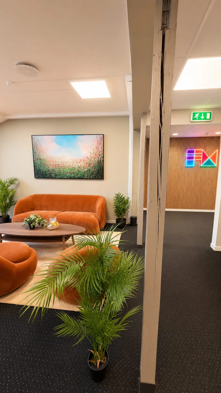 Loungen i fjerde etasje, med FM CyberSecurity-logoen i neon på veggen bak