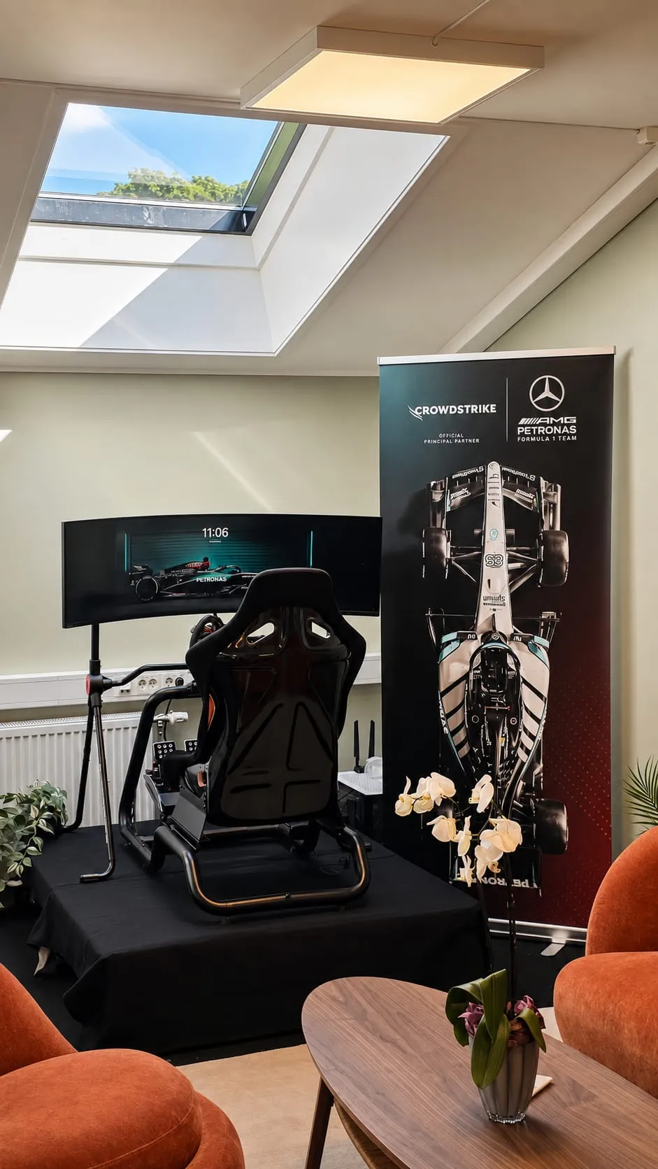 Racingsimulator-stolen vår foran en CrowdStrike og Mercedes-AMG Petronas F1-rollup på kontoret